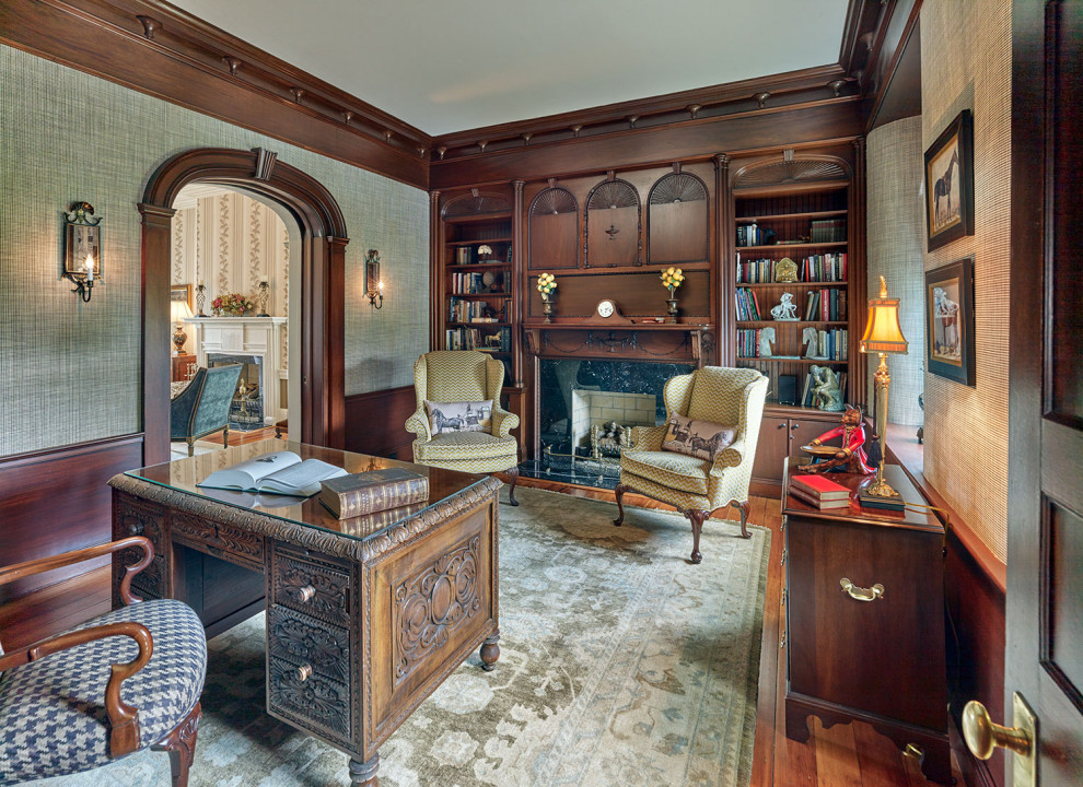 Inspiration for a traditional home office in Philadelphia with a library, beige walls, medium hardwood floors, a standard fireplace, a stone fireplace surround, a freestanding desk and wallpaper.