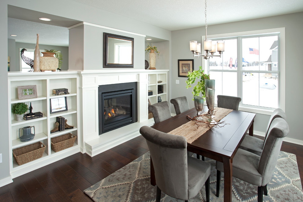 Traditional dining room in Minneapolis with grey walls, dark hardwood floors and a two-sided fireplace.