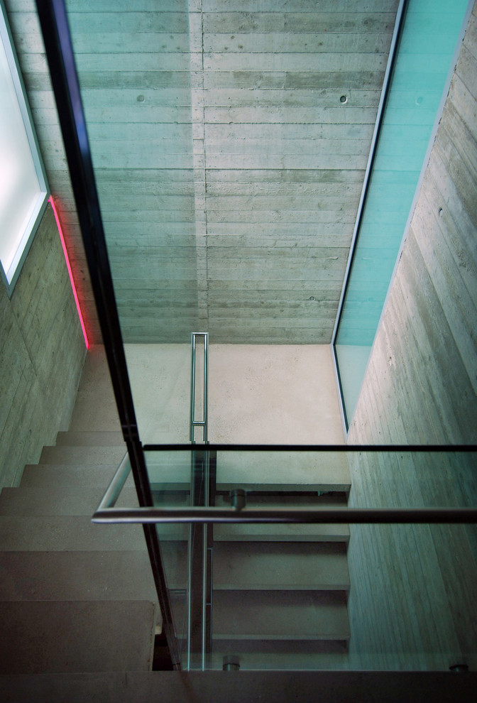 Inspiration for a mid-sized contemporary concrete u-shaped staircase in London with open risers.
