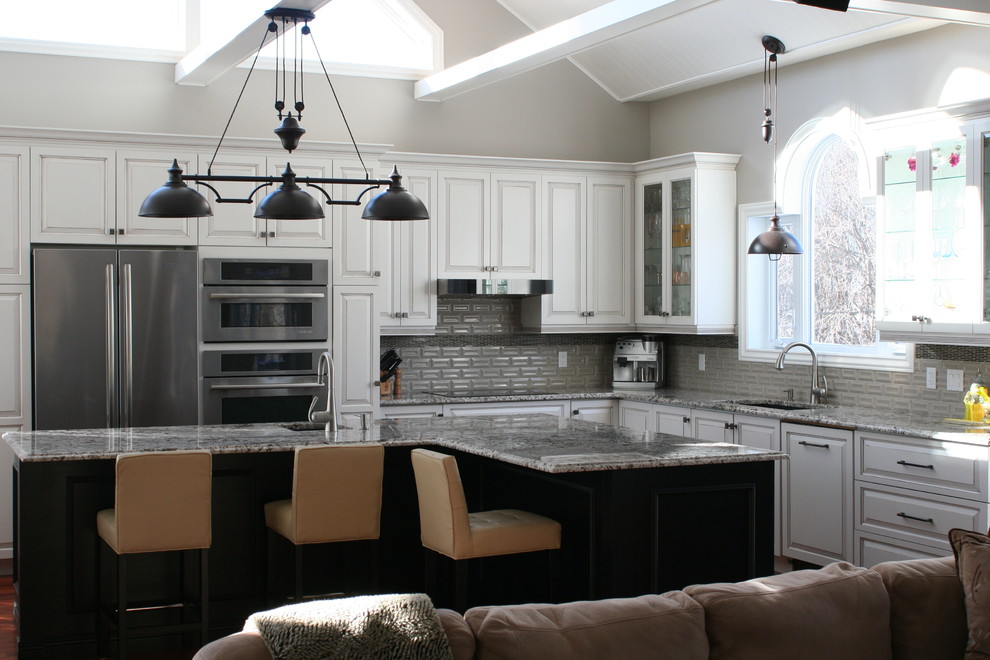 Inspiration for a huge transitional l-shaped medium tone wood floor and brown floor open concept kitchen remodel in Montreal with an undermount sink, glass-front cabinets, white cabinets, granite countertops, gray backsplash, ceramic backsplash, stainless steel appliances, an island and multicolored countertops