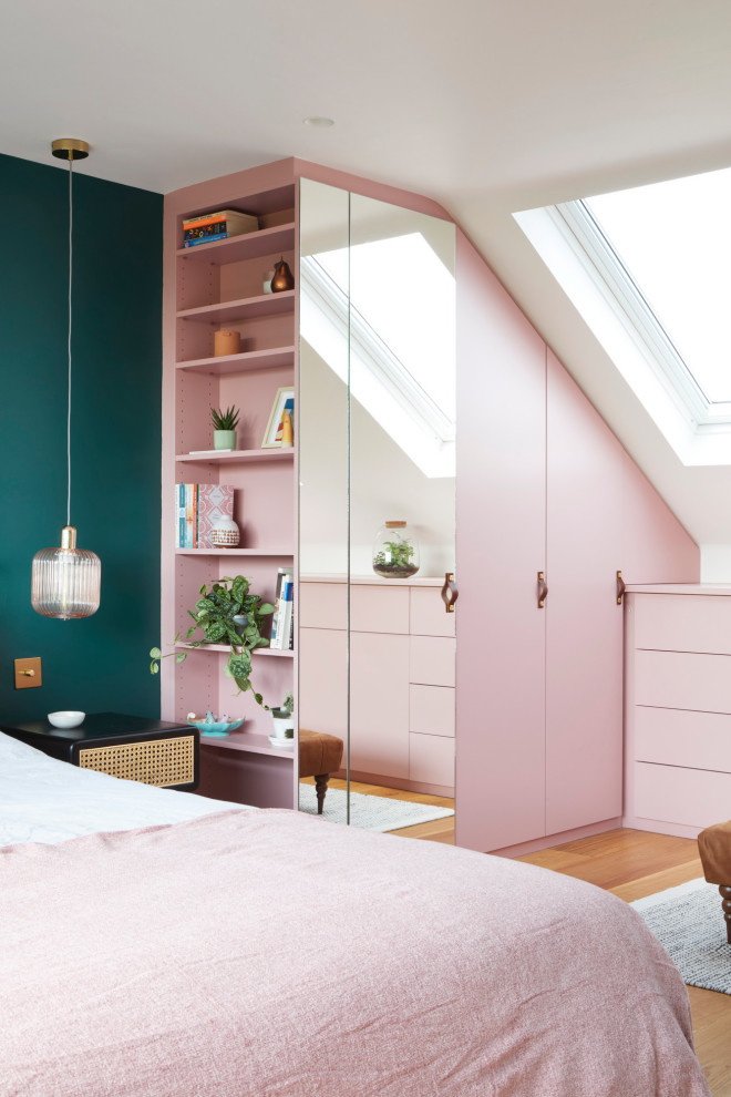 Großes Modernes Schlafzimmer mit grüner Wandfarbe und braunem Holzboden in London
