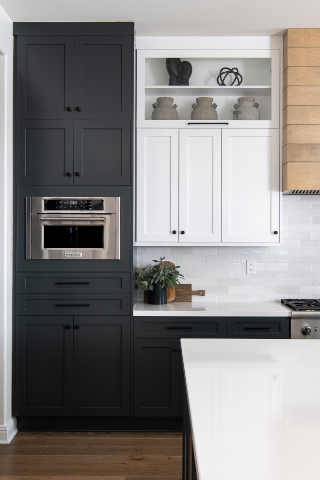 Transitional porcelain tile and gray floor kitchen photo in Orange County with a farmhouse sink, shaker cabinets, white cabinets, quartzite countertops, white backsplash, subway tile backsplash, stainless steel appliances, an island and white countertops