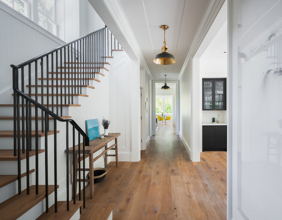 Design ideas for a mid-sized transitional hallway in San Francisco with white walls, medium hardwood floors and brown floor.