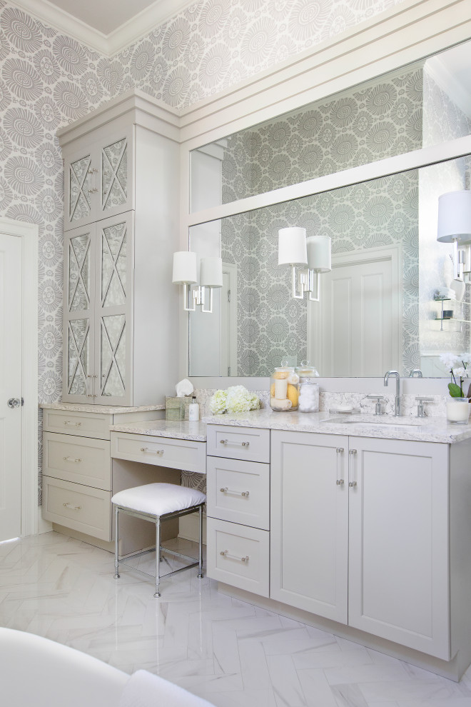 Inspiration for a mid-sized traditional master bathroom in Charleston with recessed-panel cabinets, grey cabinets, white tile, porcelain tile, porcelain floors, an undermount sink, engineered quartz benchtops, white floor, a hinged shower door, grey benchtops, an enclosed toilet, a double vanity, a built-in vanity, wallpaper and a freestanding tub.
