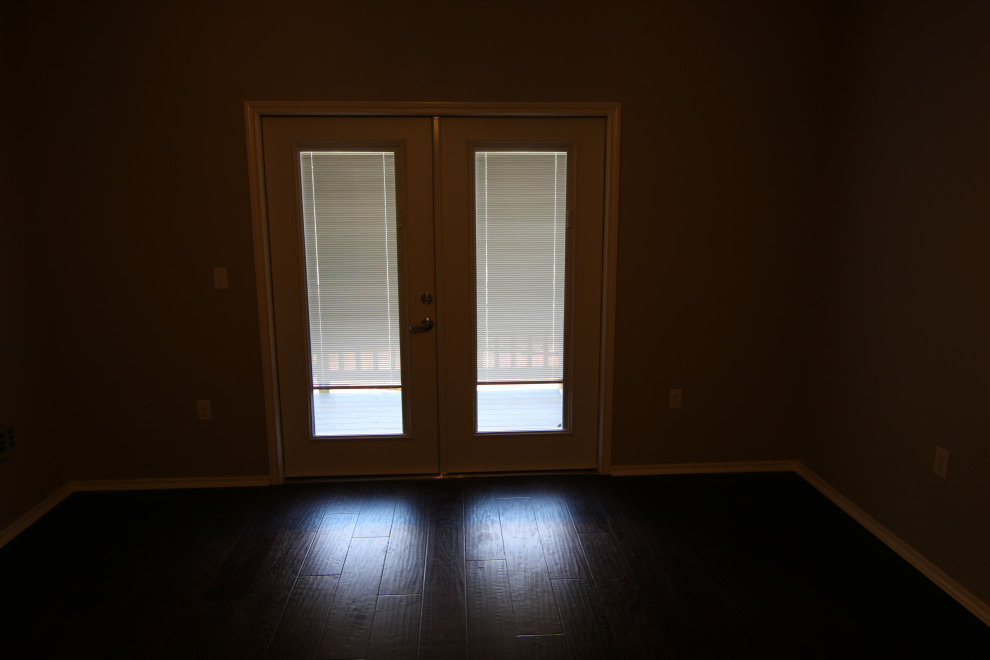 This is an example of a large traditional master bedroom in Austin with dark hardwood floors and brown floor.