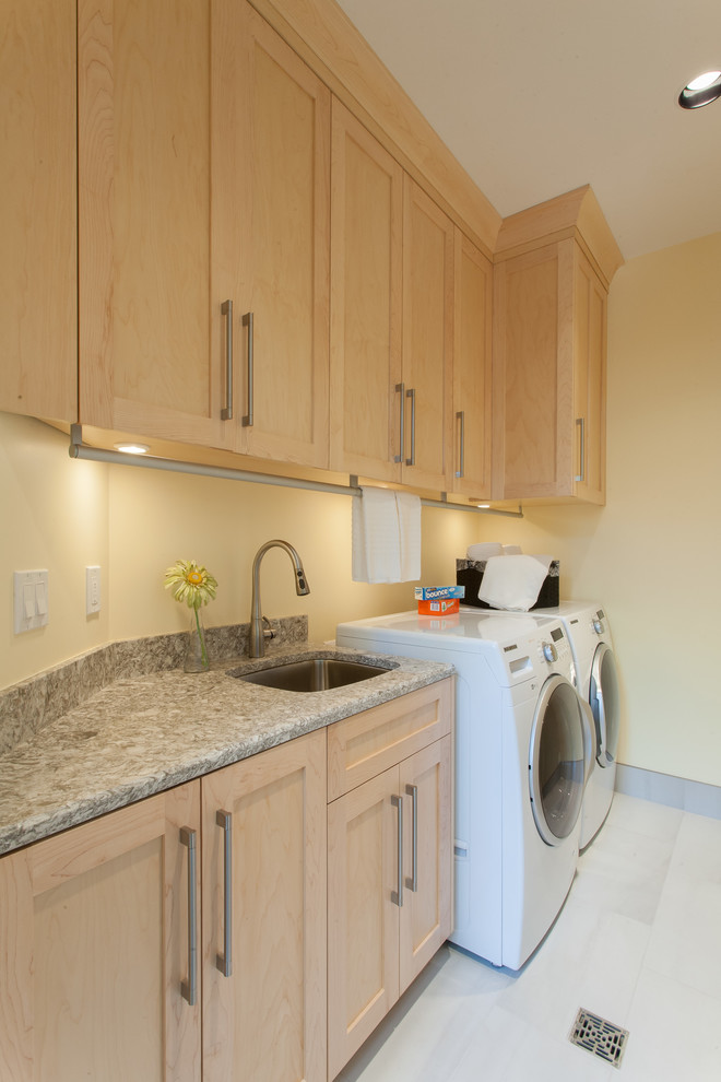 Mid-sized arts and crafts galley dedicated laundry room in Vancouver with an undermount sink, shaker cabinets, light wood cabinets, quartz benchtops, ceramic floors, a side-by-side washer and dryer and beige walls.