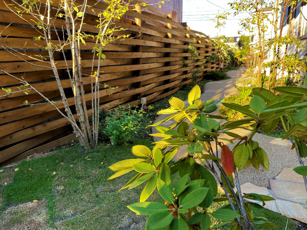 На фото: солнечный, летний участок и сад среднего размера на внутреннем дворе в стиле кантри с перегородкой для приватности, хорошей освещенностью, покрытием из каменной брусчатки и с деревянным забором