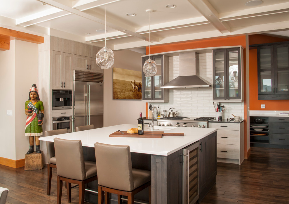 Inspiration for a transitional dark wood floor kitchen remodel in Seattle with an undermount sink, shaker cabinets, light wood cabinets, white backsplash, subway tile backsplash, stainless steel appliances and an island