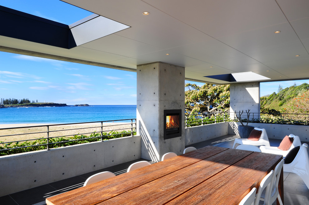 Inspiration for a contemporary patio in Sydney with a fire feature and a roof extension.