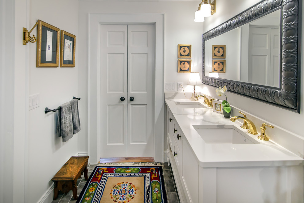 This is an example of a mid-sized transitional master bathroom in Charlotte with shaker cabinets, white cabinets, white walls, ceramic floors, an undermount sink, engineered quartz benchtops, grey floor and white benchtops.