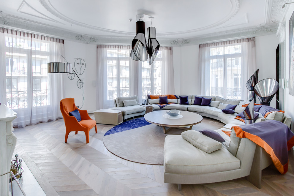 Large contemporary living room in Paris with white walls, light hardwood floors and a standard fireplace.