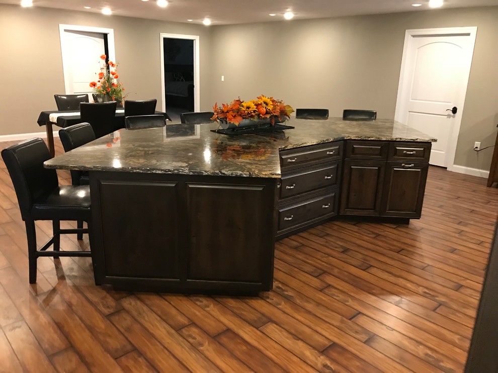 Inspiration for a large timeless galley dark wood floor and brown floor open concept kitchen remodel with raised-panel cabinets, granite countertops, stainless steel appliances, an undermount sink, dark wood cabinets and an island
