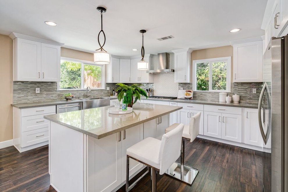 Kitchen - transitional l-shaped dark wood floor kitchen idea in Miami with a farmhouse sink, shaker cabinets, white cabinets, multicolored backsplash, matchstick tile backsplash, stainless steel appliances and an island
