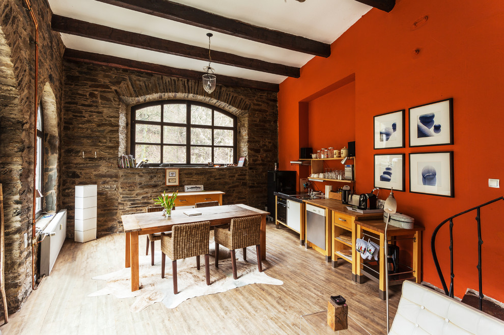Design ideas for a mid-sized country single-wall eat-in kitchen in Dusseldorf with open cabinets, wood benchtops, orange splashback, stainless steel appliances, light hardwood floors and beige floor.