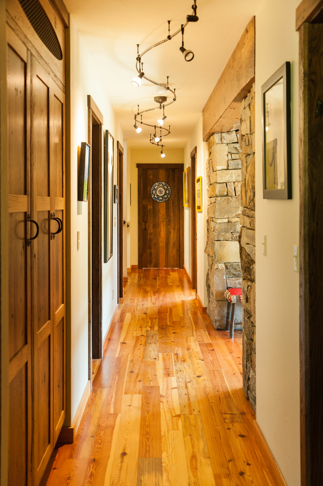 Mid-sized mountain style brown floor and medium tone wood floor hallway photo in Seattle with beige walls