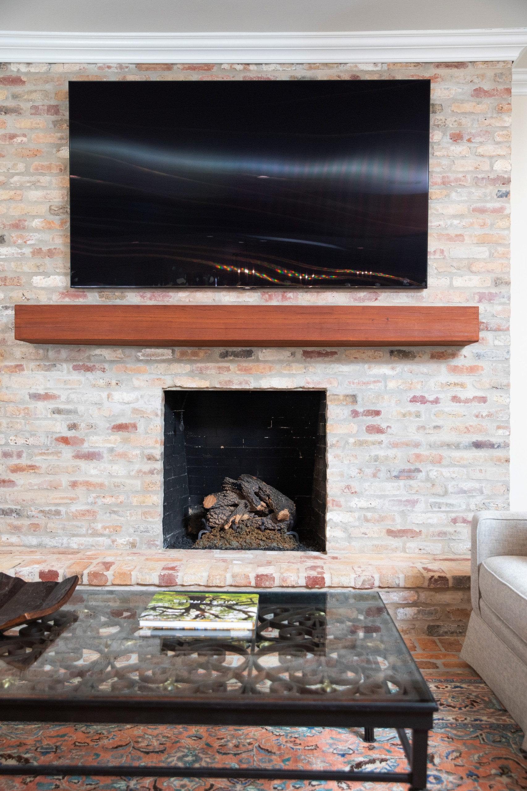 Mid-sized elegant open concept living room photo in New Orleans with a standard fireplace, a brick fireplace and a wall-mounted tv