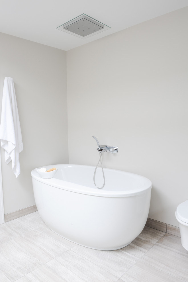 Inspiration for a mid-sized contemporary master bathroom in Vancouver with a freestanding tub, a wall-mount toilet, stone tile, limestone floors, flat-panel cabinets, medium wood cabinets, a corner shower, white walls and an undermount sink.