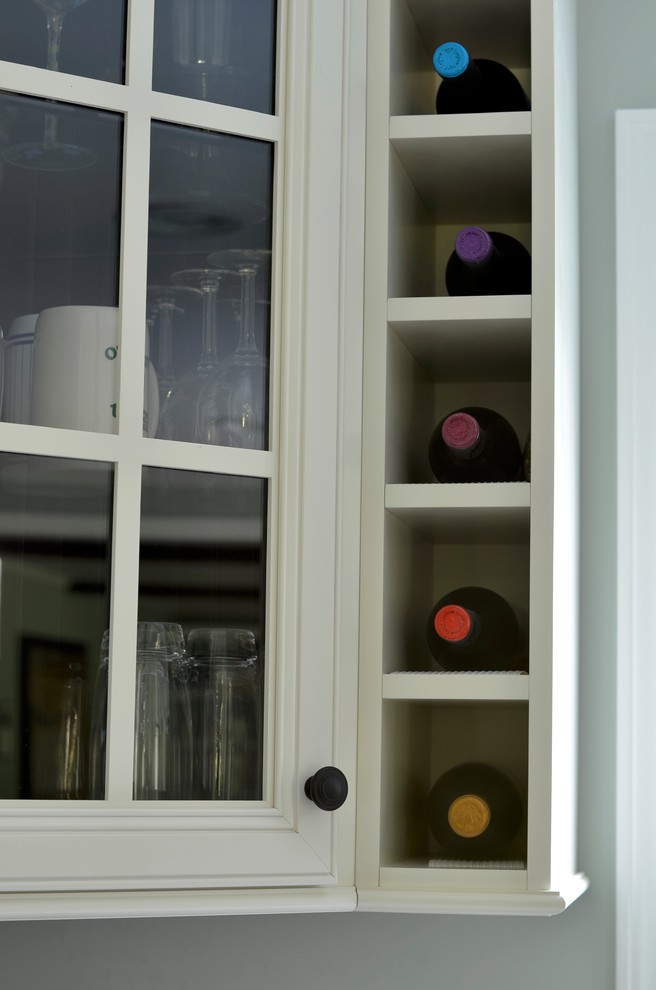 Eat-in kitchen - transitional eat-in kitchen idea in New York with glass-front cabinets, white cabinets and granite countertops