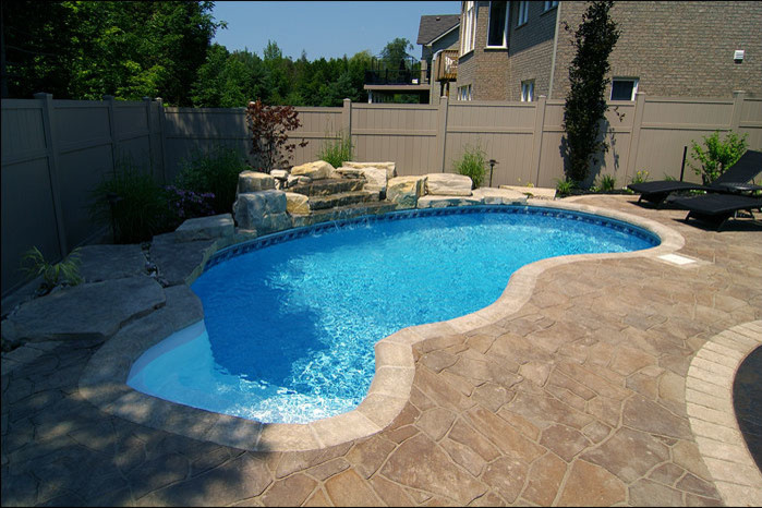 Pool - mid-sized transitional backyard custom-shaped and concrete paver lap pool idea in Toronto