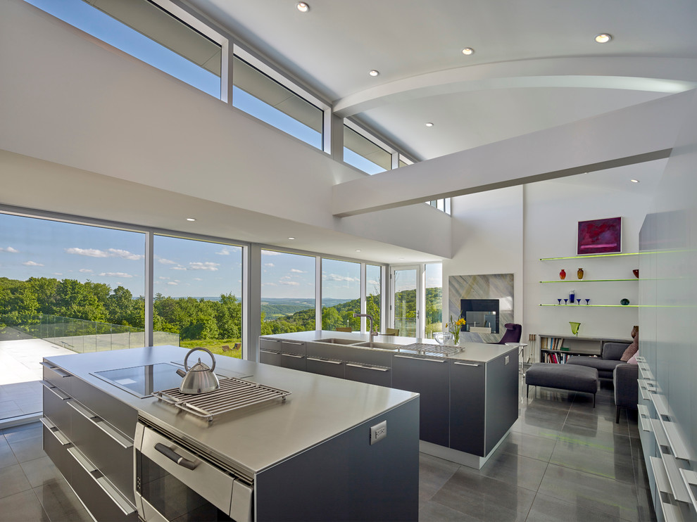 This is an example of a large modern l-shaped eat-in kitchen in Philadelphia with a double-bowl sink, flat-panel cabinets, stainless steel cabinets, stainless steel benchtops, stainless steel appliances, ceramic floors, multiple islands and black floor.