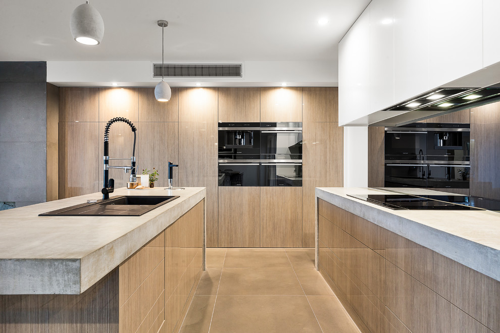Contemporary kitchen in Melbourne with a double-bowl sink, recessed-panel cabinets, light wood cabinets, concrete benchtops, black splashback, glass sheet splashback, limestone floors, with island and grey floor.
