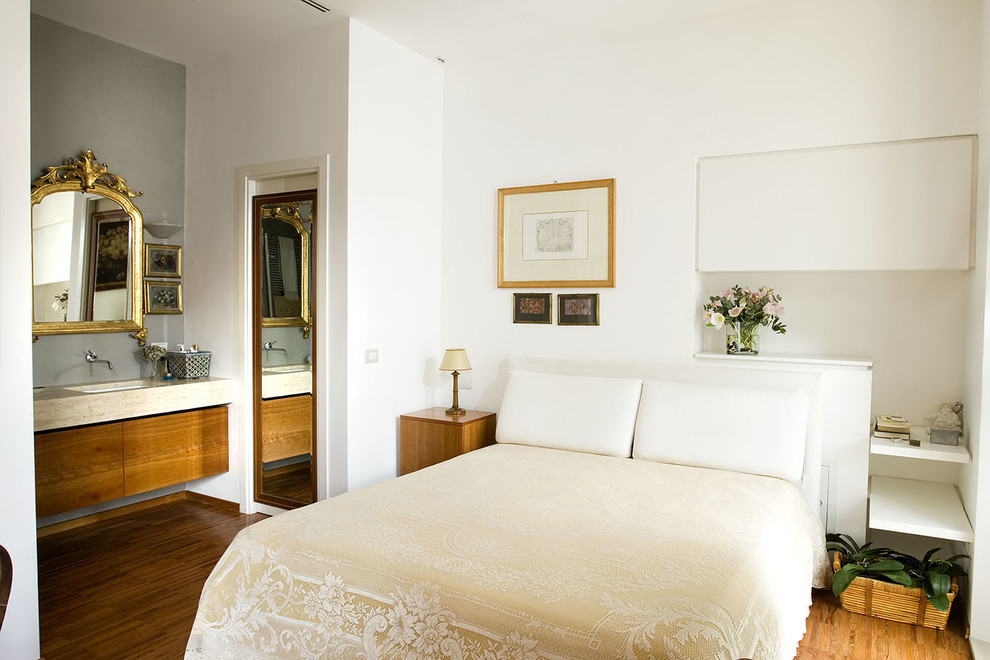 Design ideas for a traditional master bedroom in Rome with white walls and light hardwood floors.