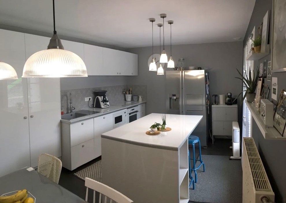 Inspiration for a large industrial galley separate kitchen in Paris with a single-bowl sink, flat-panel cabinets, white cabinets, laminate benchtops, grey splashback, stainless steel appliances, painted wood floors, with island, grey floor and white benchtop.