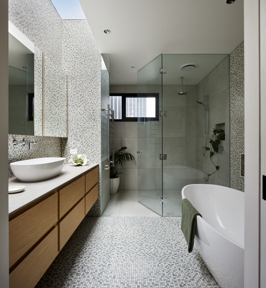 Large contemporary bathroom in Melbourne with a single vanity, mosaic tile floors, solid surface benchtops, grey benchtops and a niche.