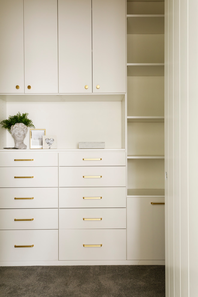 Medium sized traditional gender neutral walk-in wardrobe in Boise with flat-panel cabinets, white cabinets, carpet and grey floors.