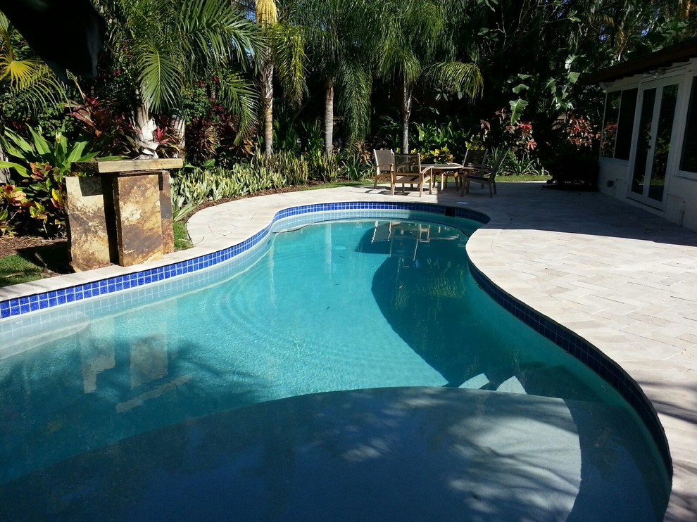 Pool house - large backyard stone and custom-shaped pool house idea in Miami