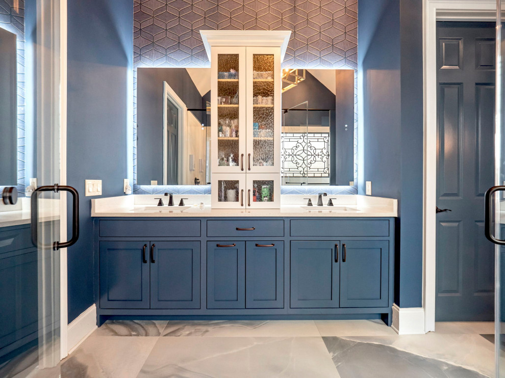 Design ideas for a mid-sized transitional master bathroom in Other with shaker cabinets, blue cabinets, a freestanding tub, a shower/bathtub combo, a bidet, white tile, porcelain tile, blue walls, porcelain floors, an undermount sink, quartzite benchtops, blue floor, a hinged shower door, white benchtops, an enclosed toilet, a double vanity, a built-in vanity, vaulted and wallpaper.
