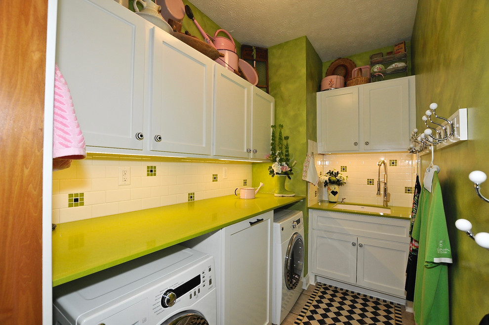 Photo of a small eclectic l-shaped dedicated laundry room in Indianapolis with an undermount sink, recessed-panel cabinets, white cabinets, quartz benchtops, green walls, ceramic floors, a side-by-side washer and dryer and green benchtop.