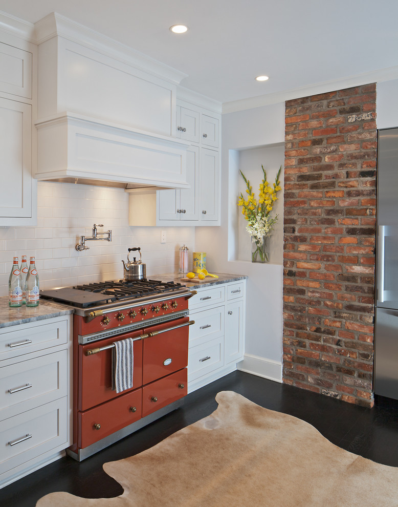 This is an example of a mid-sized traditional separate kitchen in DC Metro with shaker cabinets, white cabinets, white splashback, subway tile splashback, coloured appliances, dark hardwood floors, no island and granite benchtops.