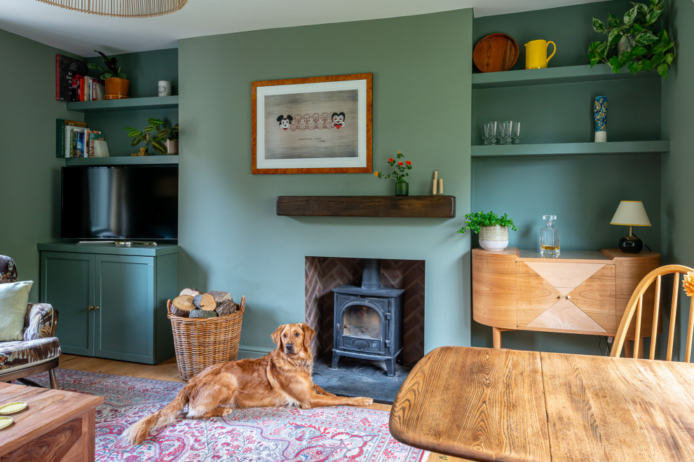 Foto de salón campestre pequeño con paredes verdes, estufa de leña y panelado