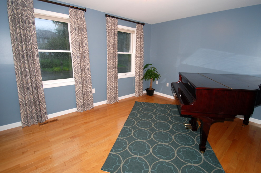 Small transitional enclosed living room in Manchester with a music area, blue walls and medium hardwood floors.