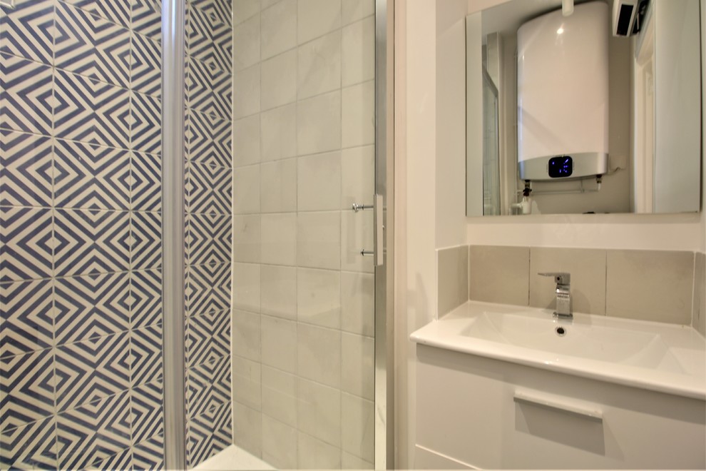 Inspiration for a small contemporary master bathroom in Paris with a one-piece toilet, blue tile, ceramic tile, white walls, ceramic floors, a console sink, blue floor, a sliding shower screen and white benchtops.