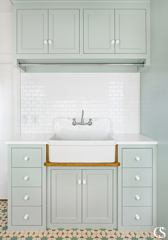 Design ideas for a large traditional utility room in Salt Lake City with a belfast sink, green cabinets, white splashback, metro tiled splashback, white walls and white worktops.