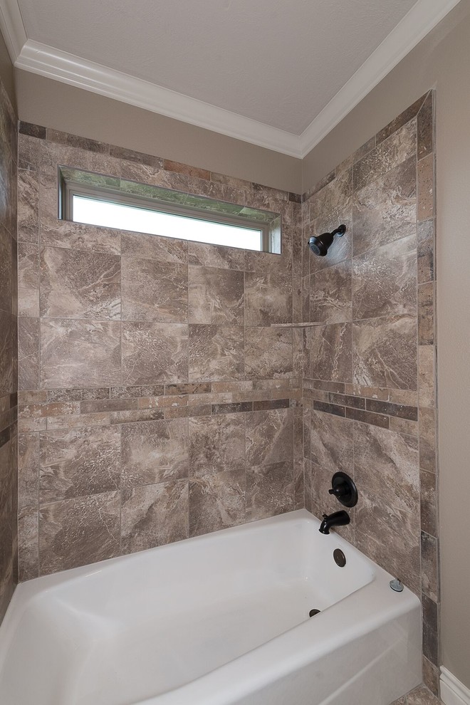 Photo of a mid-sized country 3/4 bathroom in Austin with shaker cabinets, medium wood cabinets, an alcove tub, a shower/bathtub combo, a two-piece toilet, brown tile, travertine, beige walls, brick floors, an undermount sink, granite benchtops, brown floor and an open shower.