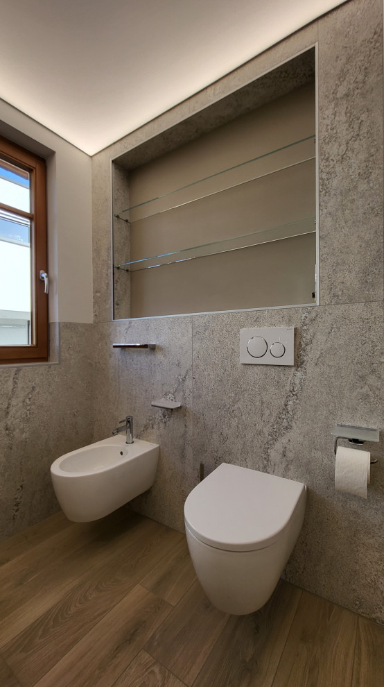 Medium sized cloakroom in Frankfurt with a two-piece toilet, beige walls, wood-effect flooring, a vessel sink, brown floors and a drop ceiling.