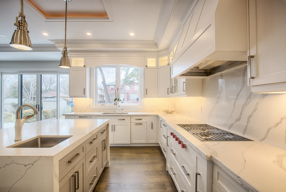 Enclosed kitchen - large contemporary l-shaped dark wood floor and brown floor enclosed kitchen idea in Toronto with an undermount sink, shaker cabinets, white cabinets, marble countertops, white backsplash, marble backsplash, paneled appliances, an island and white countertops