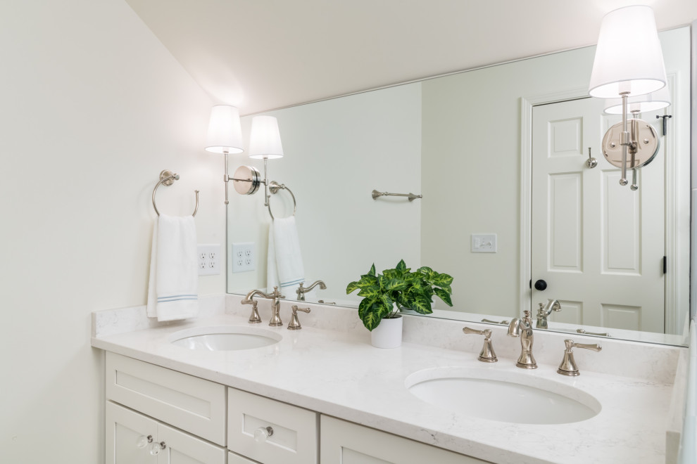 Photo of a medium sized classic family bathroom in Atlanta with shaker cabinets, white cabinets, an alcove shower, a two-piece toilet, white tiles, porcelain tiles, white walls, concrete flooring, a submerged sink, engineered stone worktops, multi-coloured floors, a hinged door, white worktops, a wall niche, double sinks and a built in vanity unit.
