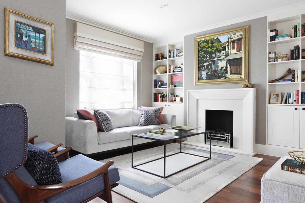 This is an example of a transitional living room in Other with a library, grey walls, dark hardwood floors, a standard fireplace and brown floor.