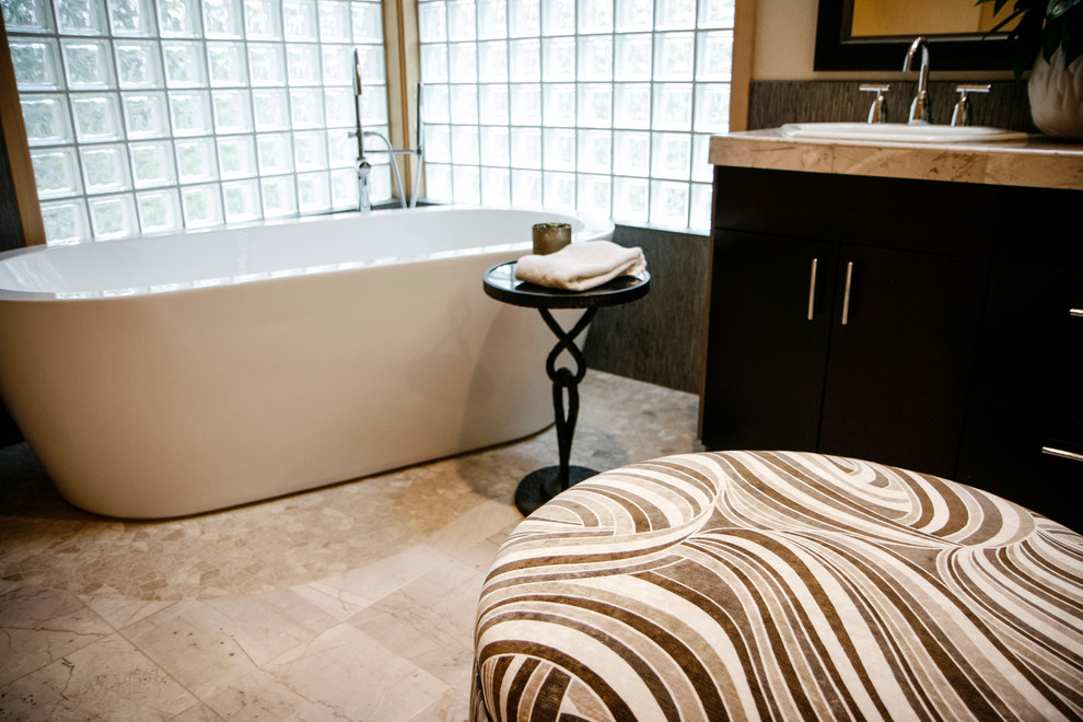 Mid-sized transitional master beige tile and stone tile freestanding bathtub photo with flat-panel cabinets, dark wood cabinets and beige walls