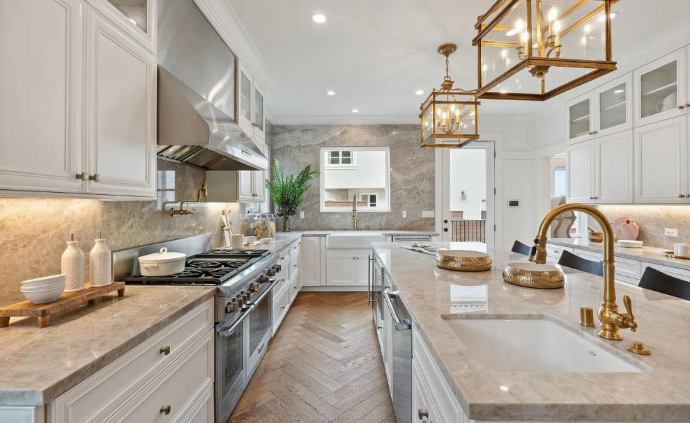 Inspiration for a large u-shaped eat-in kitchen in San Francisco with a farmhouse sink, recessed-panel cabinets, white cabinets, granite benchtops, multi-coloured splashback, granite splashback, stainless steel appliances, light hardwood floors, with island, multi-coloured floor and multi-coloured benchtop.