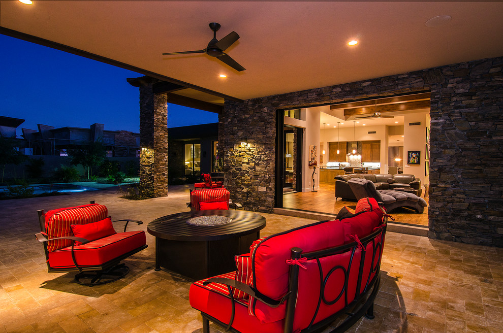 Design ideas for a contemporary patio in Phoenix with a fire feature, tile and a roof extension.