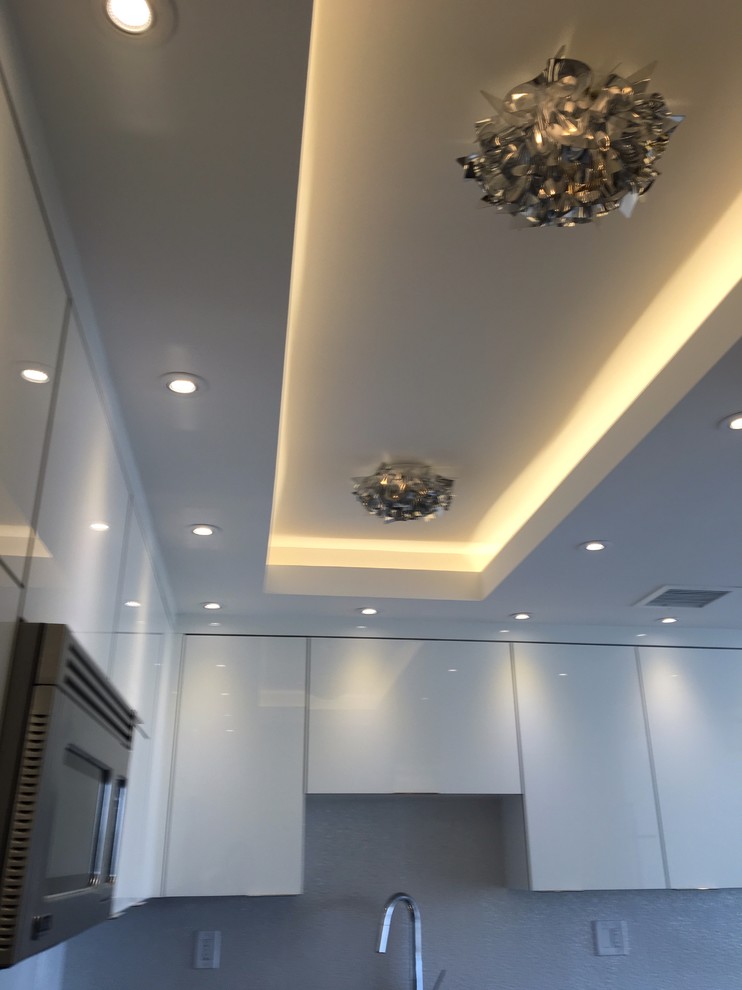 Interesting ceiling with cove for lighting, hi hats and architectural light fixt
