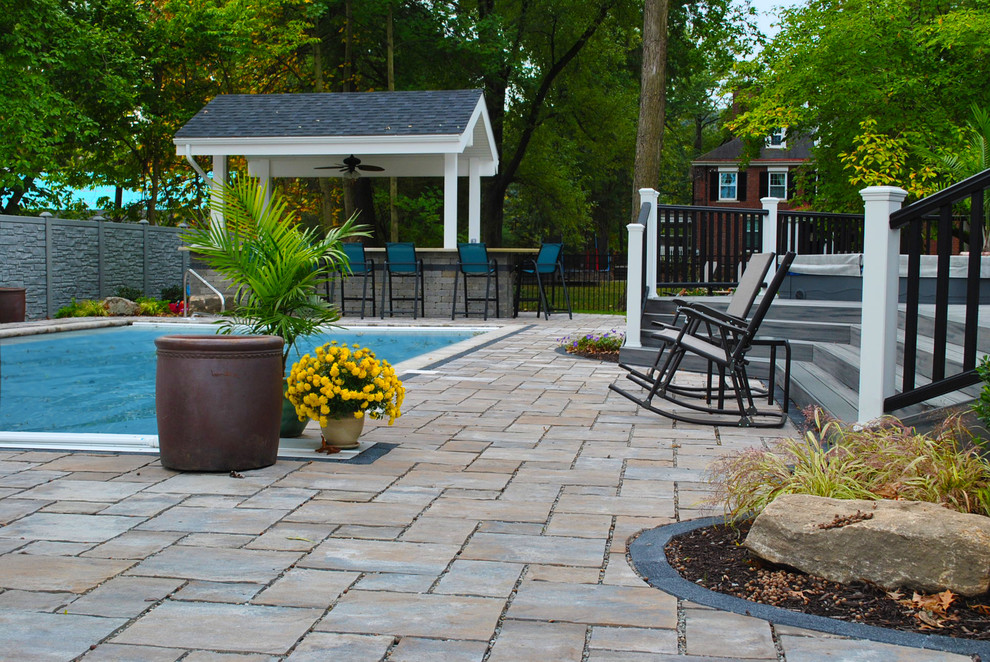 Example of a mid-sized transitional backyard concrete paver and rectangular lap hot tub design