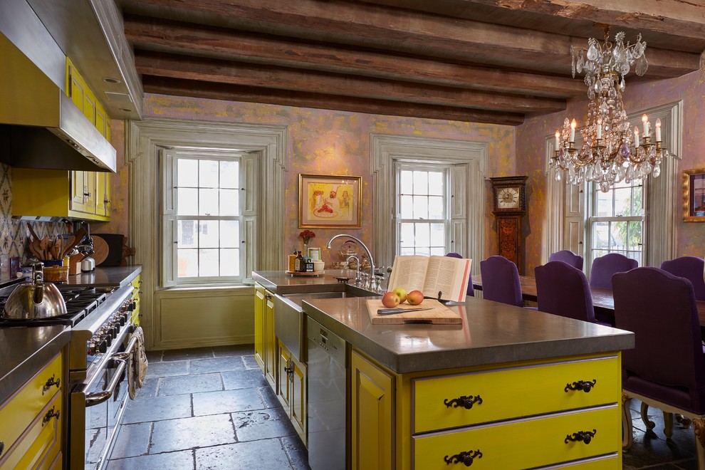 This is an example of an eclectic galley eat-in kitchen in Boston with a farmhouse sink, raised-panel cabinets, yellow cabinets, stainless steel appliances, with island, granite benchtops, multi-coloured splashback and mosaic tile splashback.