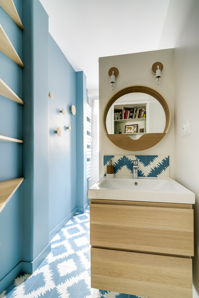 Small scandinavian powder room in Malaga with flat-panel cabinets, medium wood cabinets, ceramic tile, blue walls and ceramic floors.