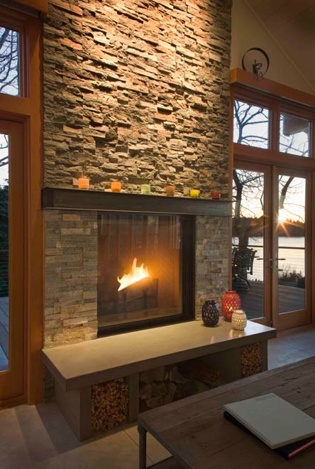 Photo of a mid-sized contemporary enclosed living room in Seattle with white walls, concrete floors, a standard fireplace and a stone fireplace surround.